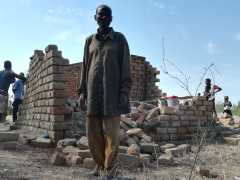 Alter Mann vor Ruine nach Zyklon Idai, Nthumba, Malawi