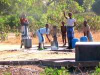 Wasser wird aus einem Brunnen gezogen und in Eimern nach Hause geschleppt.