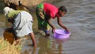 Wasserholen aus dem Fluss, weil kein Brunnen vorhanden, Ngona, Malawi